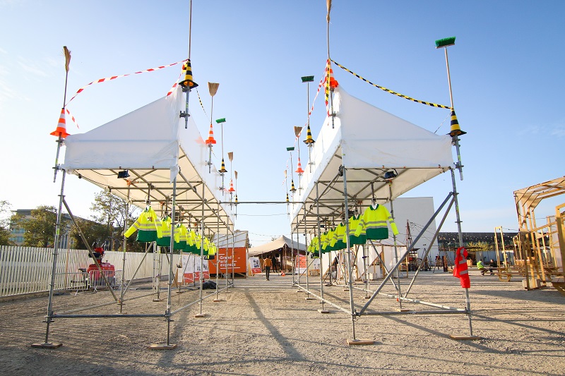 Œuvre de l’artiste Malachi Farrell composée de vestes jaunes de chantier suspendues, présentée lors du KM4 à La Courneuve