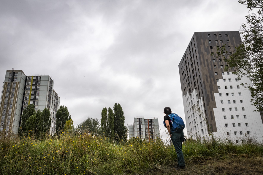 Un marcheur le long de la Bièvre à Antony devant des immeubles d’habitation