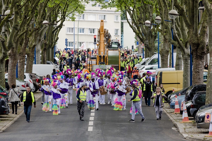 Fanfare de 40 personnes environ avec un engin de chantier en arrière-plan aux abords du KM1 à Fort-d’Issy-Vanves-Clamart-Malakoff 