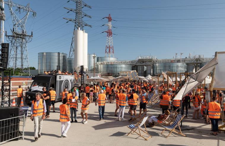 Public en gilet orange de chantier, de jour, sur le chantier de la friche Arrighi à Vitry lors du KM6