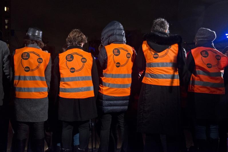 Cinq personnes de dos en gilets oranges de chantier lors du KM5 à Bagneux 